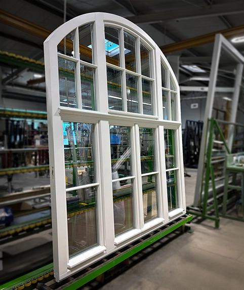 Weißes großes 3-flügliges Holzfenster mit Rundbogen und Sprossen in der Produktion Kubasch