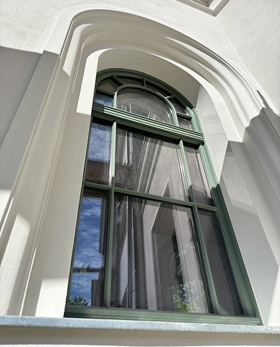 Holzfenster in Gruen mit Rundbogen für Denkmalschutzsanierung
