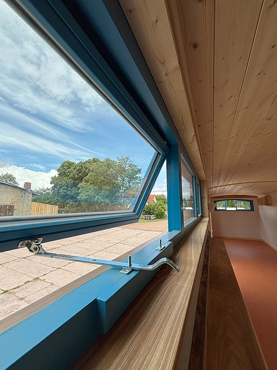 Eine Ausstellstange am Holz-Klappfenster nach aussen öffnend in blau.