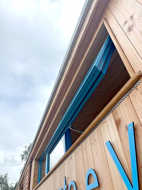 Ein zweiflügliges nach außen öffnendes Klappfenster aus Holz in Blau.