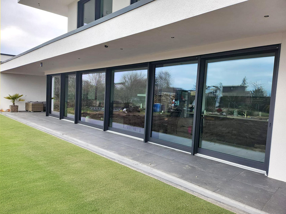 Eingangstür aus Holz in leichtem Mintgrün mit zwei Glasausschnitten mit Satinatoglas.