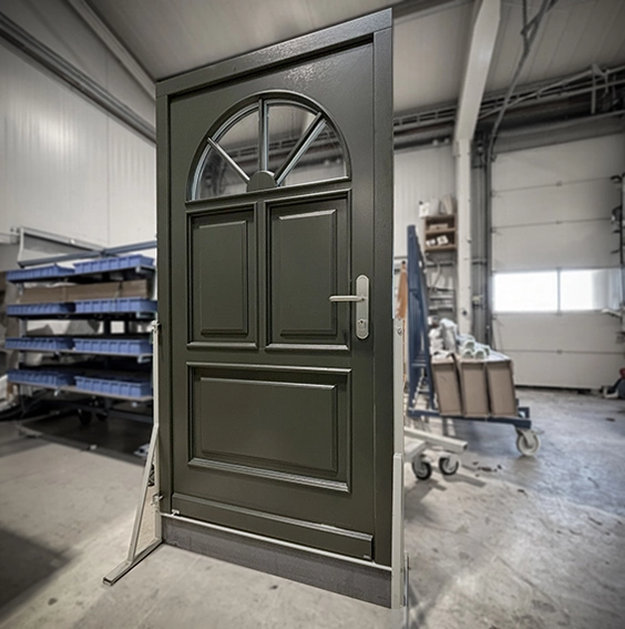 Graue Eingangstür aus Holz mit halbrunden Oberlicht