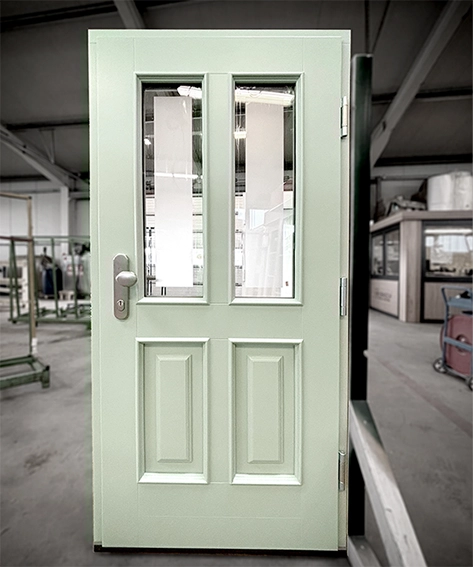 Eingangstür aus Holz in leichtem Mintgrün mit zwei Glasausschnitten mit Satinatoglas.