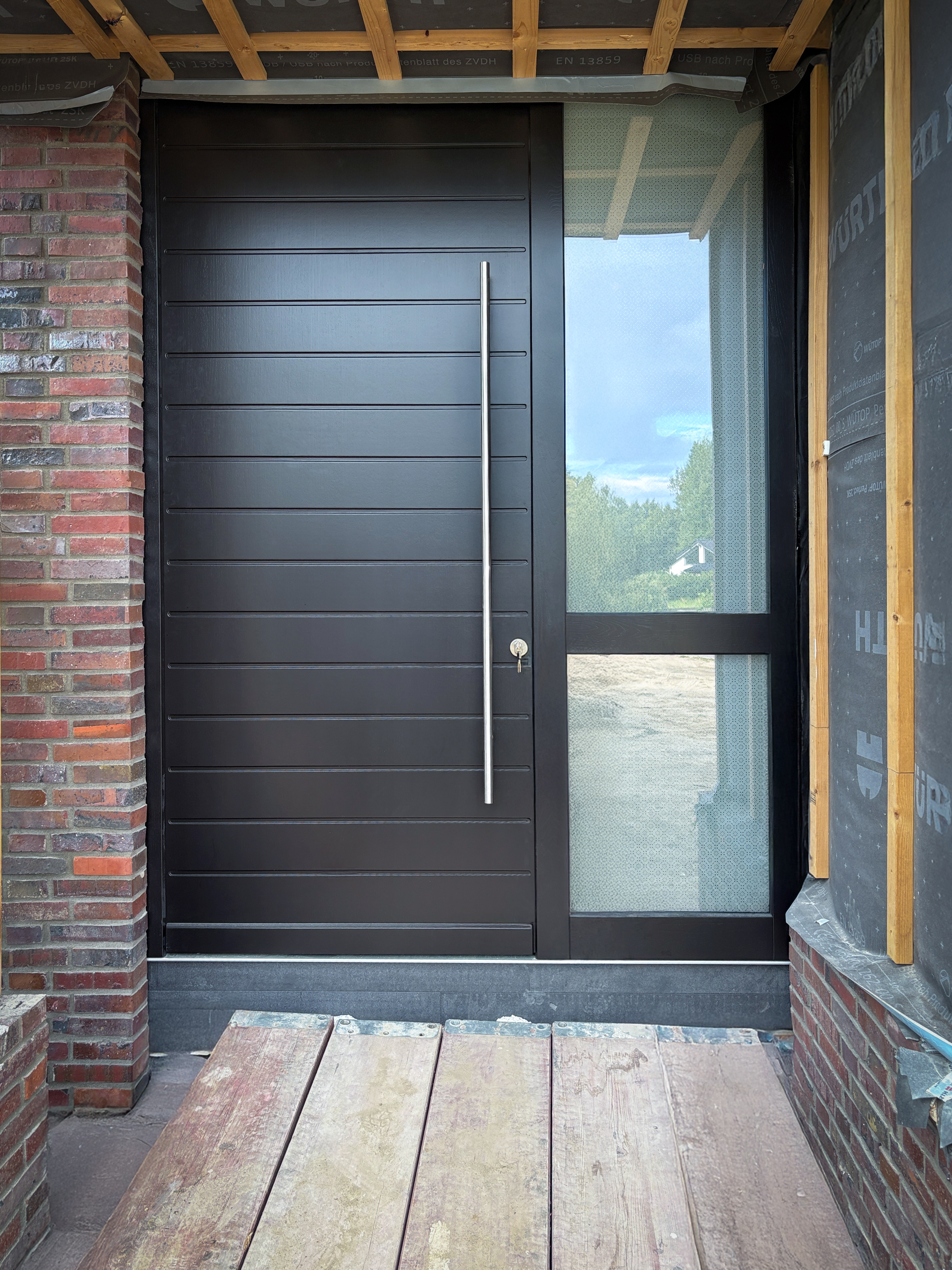 Haustür aus RedGrandis mit Lichtausschnitt und modernem Beschlag.