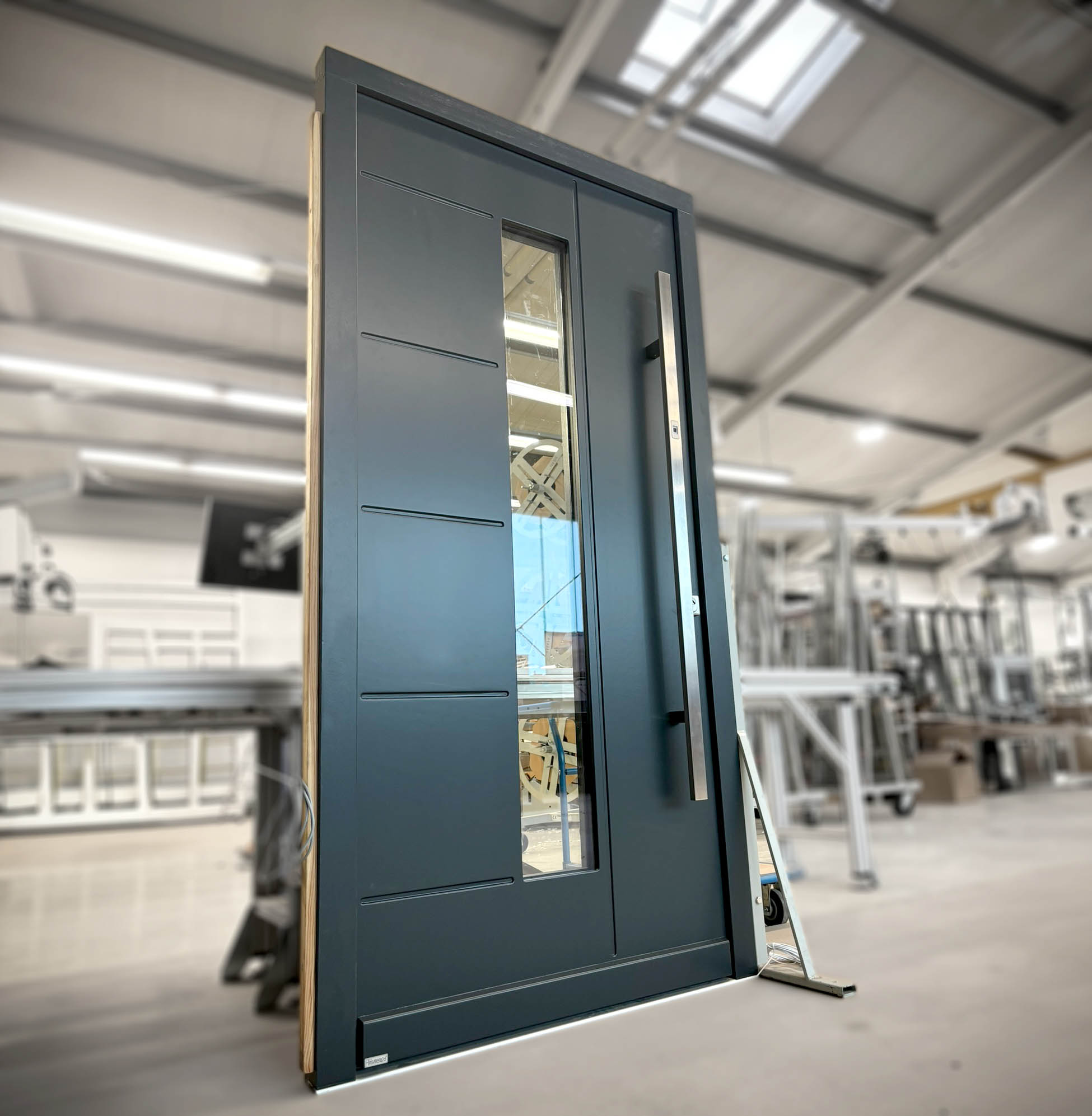 Moderne Eingangstür in Anthrazit und Lichtausschnitt sowie Querfräsungen.