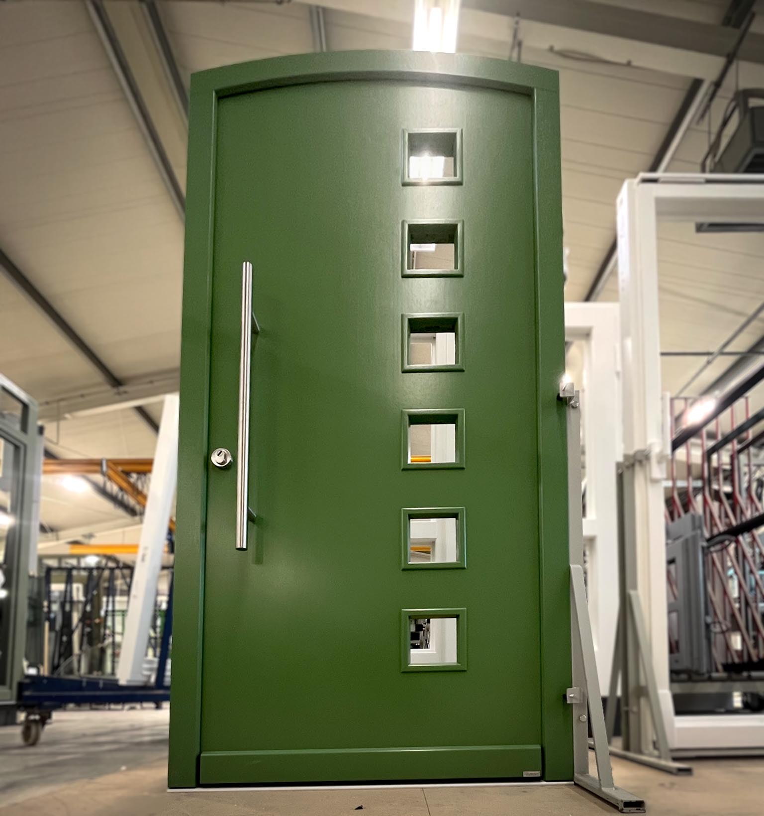 Grüne Moderne Eingangstür mit kleinen Lichtausschnitten.